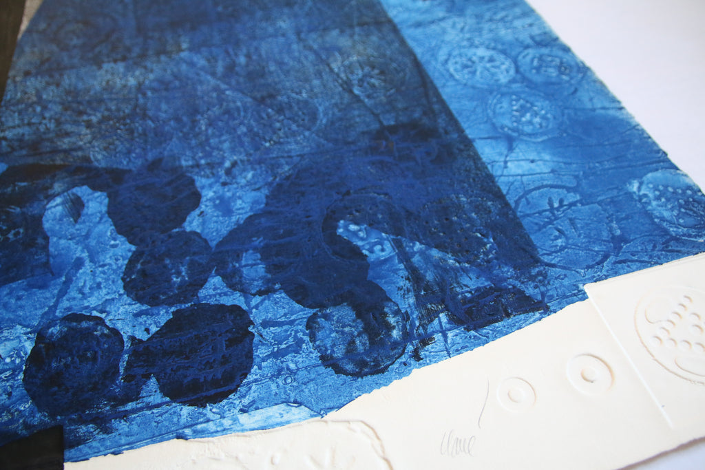 Gros plan sur la texture granuleuse du carborundum bleu et les empreintes circulaires en relief d'une gravure d'Antoni Clavé.