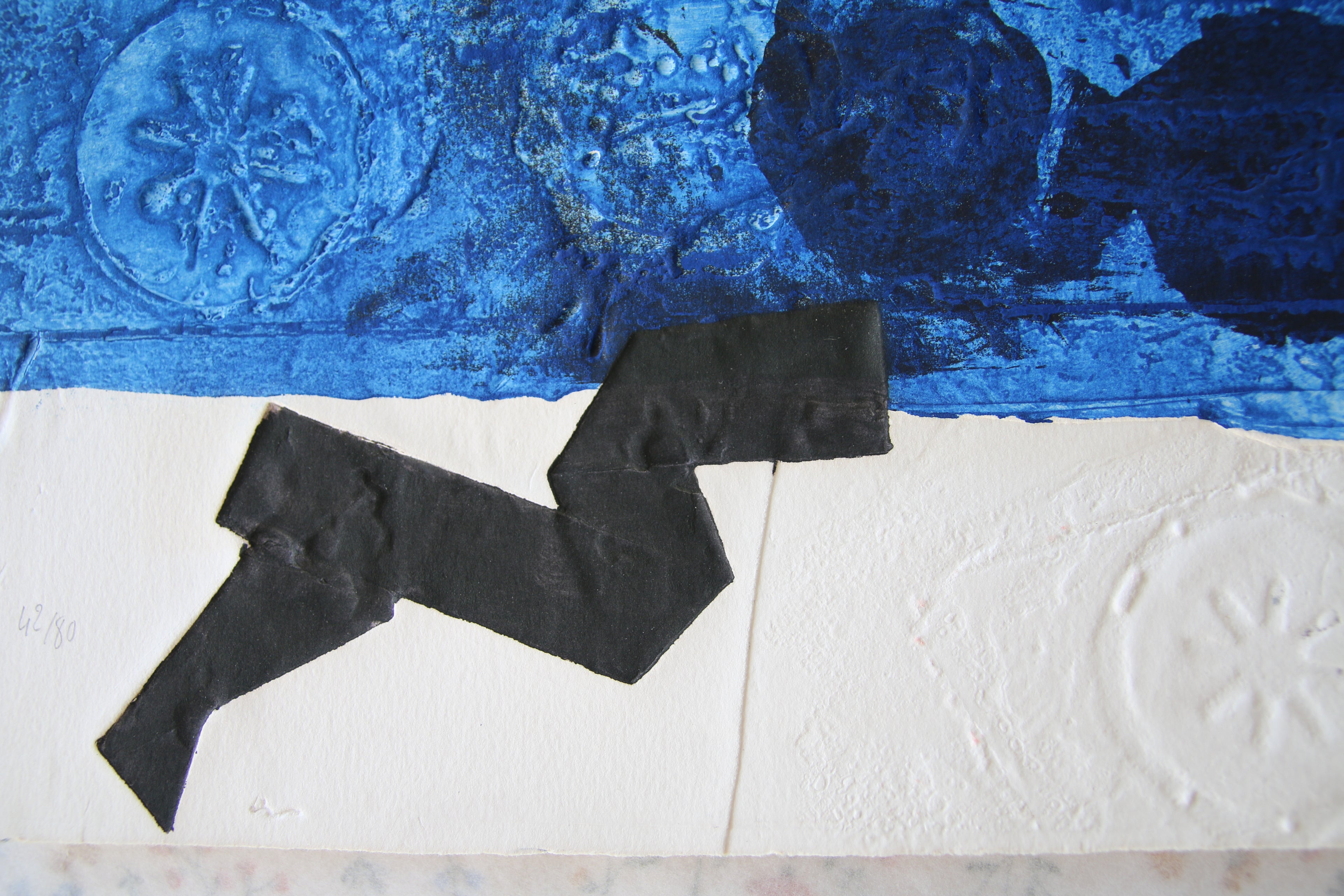 Détail du relief du gaufrage noir et des empreintes circulaires caractéristiques de la technique au carborundum d'Antoni Clavé.