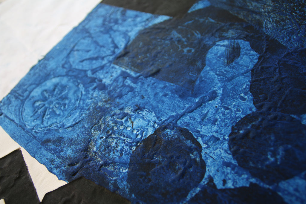 Vue rasante sur la texture granuleuse et les reliefs bleus profonds obtenus par la technique de gravure au carborundum d'Antoni Clavé