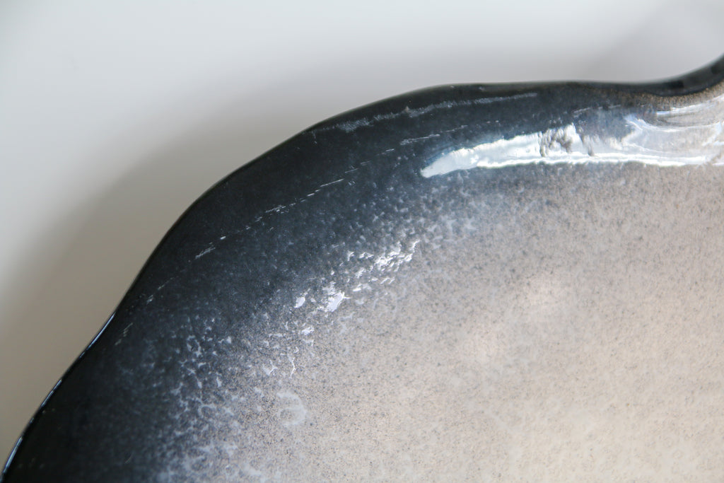 Détail de l'émaillage bicolore noir et blanc sur céramique de Pol Chambost, finition brillante