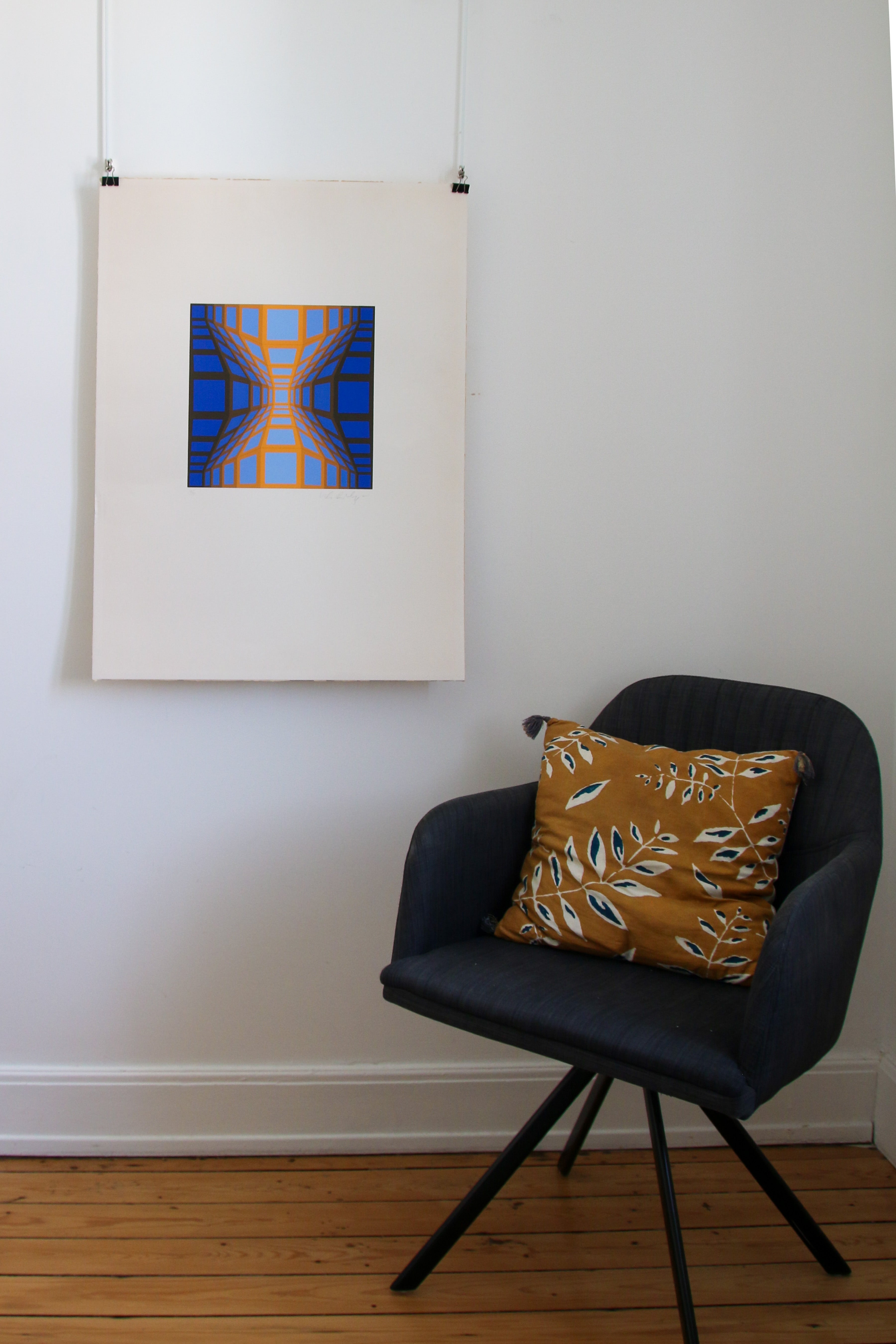 Sérigraphie Vasarely KEK-EG-II exposée dans un intérieur design avec fauteuil moderne et tons ocre