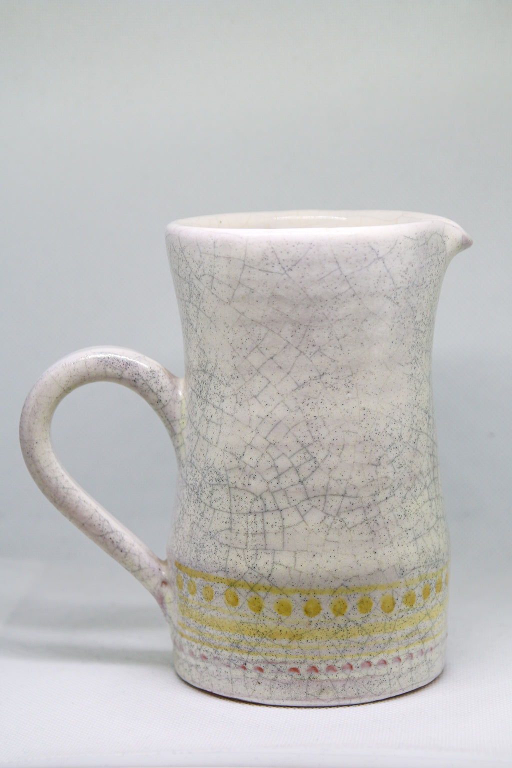 Petit pichet Roger Capron en faïence blanche craquelée, décor géométrique pointillé jaune, Vallauris circa 1955.