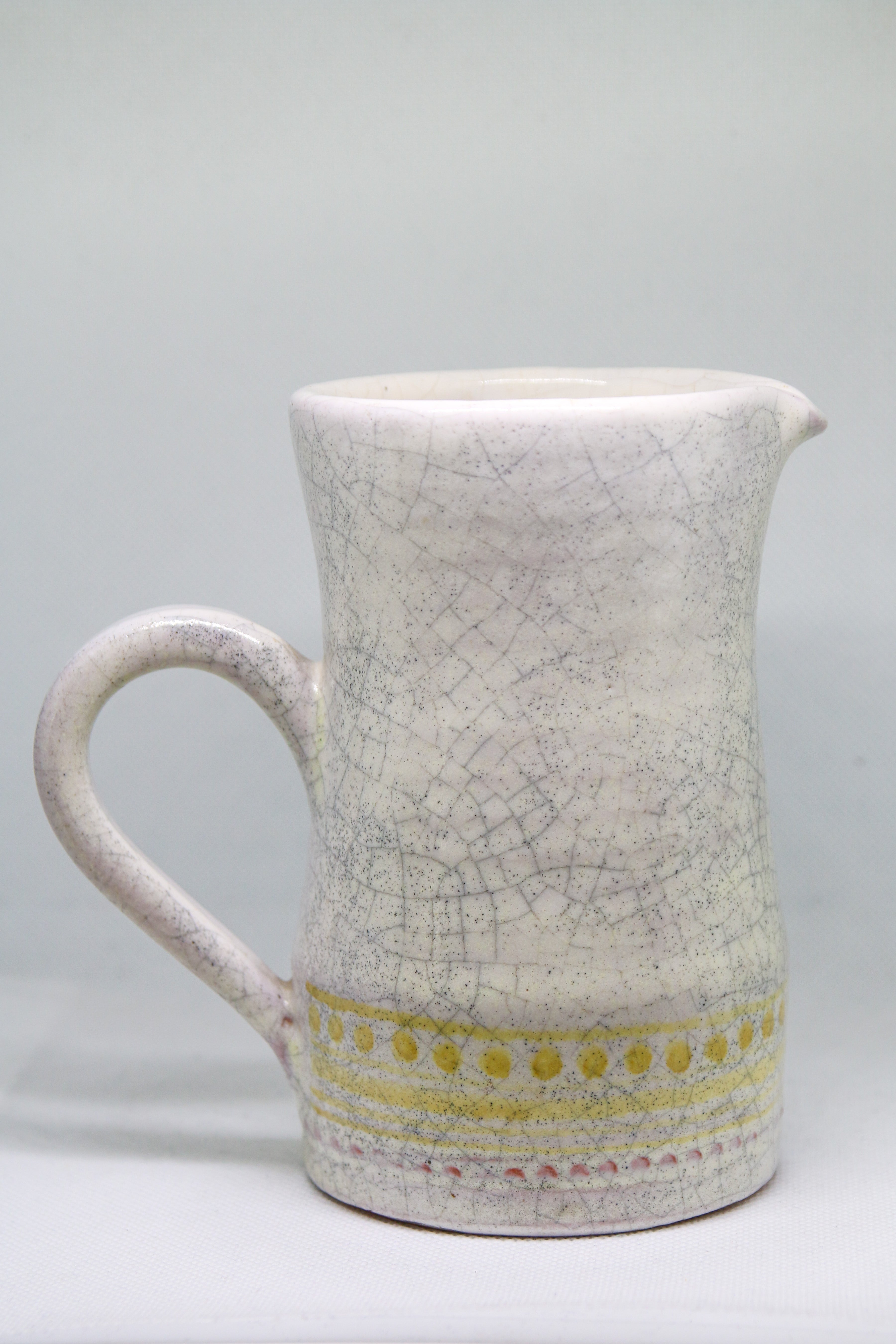 Petit pichet Roger Capron en faïence blanche craquelée, décor géométrique pointillé jaune, Vallauris circa 1955.